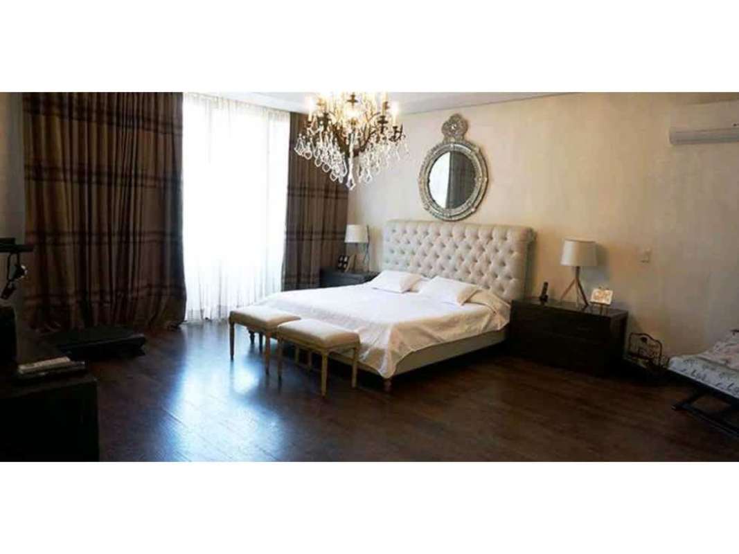 Spacious luxury bedroom with chandelier, large bed, and window Embassy Club Panama