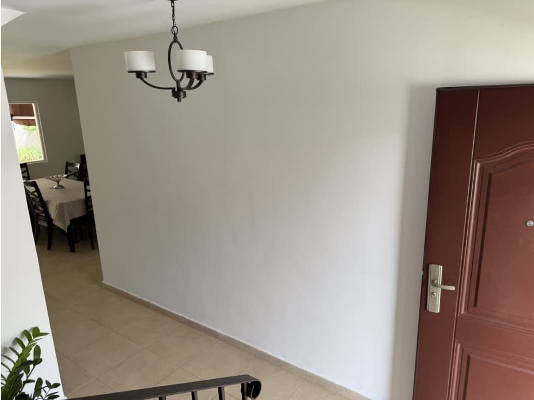 Entryway with wooden door and dining room with large window in Brisas del Golf Villa Tiber