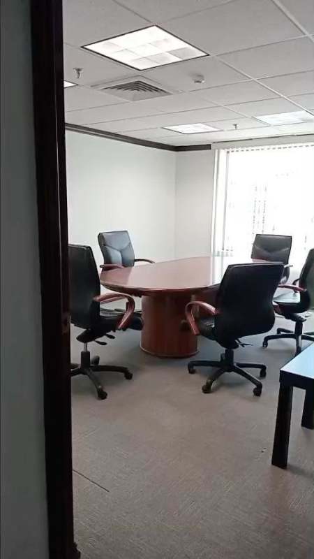 Professional conference room with wood table, black chairs, large window at Panama World Trade Center Marbella