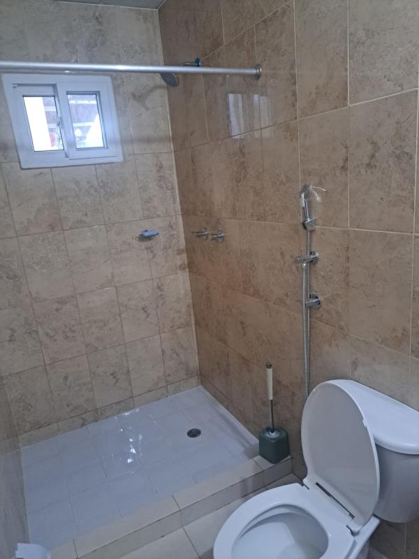 Contemporary bathroom with beige tiles, shower, and toilet PH Palermo Nuevo Tocumen