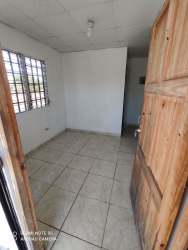 Empty bedroom with tiled floor, white walls and grilled window in Santa Cruz Apartments David Chiriquí Panama