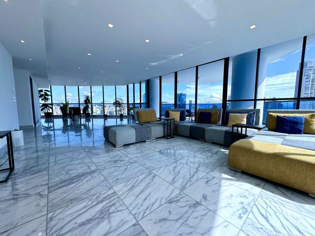 Open-plan living room and dining with panoramic city and ocean views at PH Ocean Front