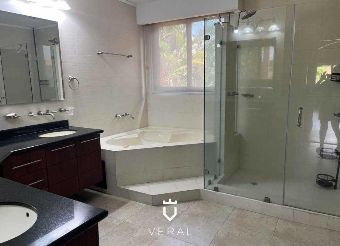 Modern master bathroom with double sinks, large glass shower enclosure, corner soaking tub in luxury house Costa del Este Panama