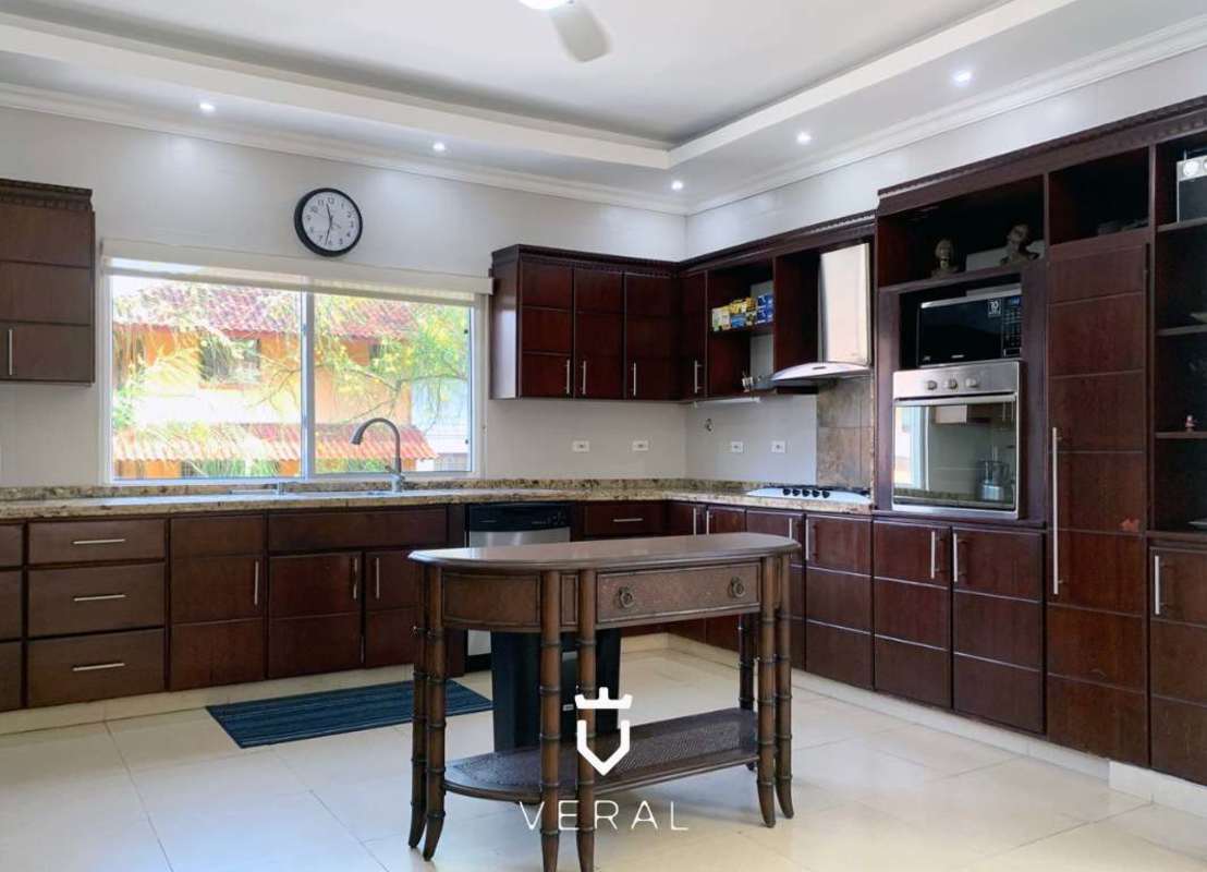Modern spacious kitchen with granite countertops and wood cabinets in Albrook residence Panama