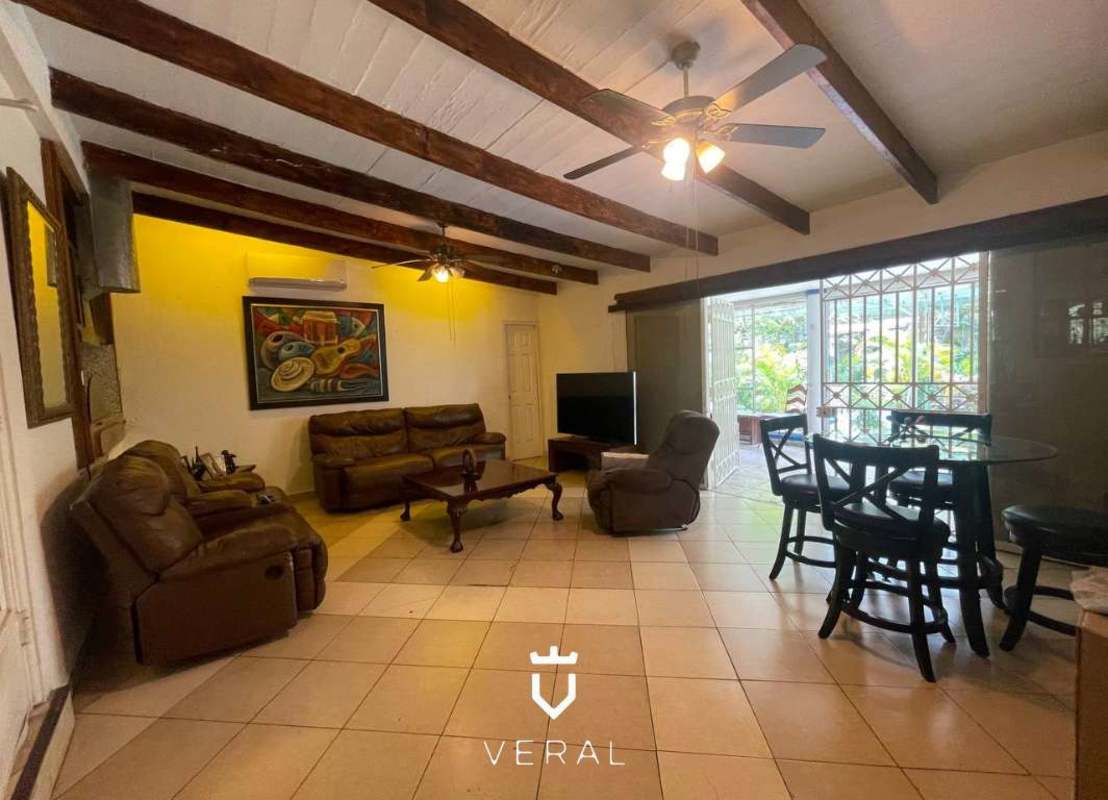 Bright bedroom with large windows and garden views in Panama City home for sale