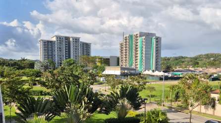 Outdoor swimming pool and landscaped gardens at PH Midrise Panama Pacifico Veracruz