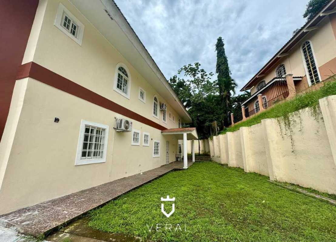 Covered balcony with white columns overlooking lush gardens at Villa del Lago Las Cumbres Panama luxury home