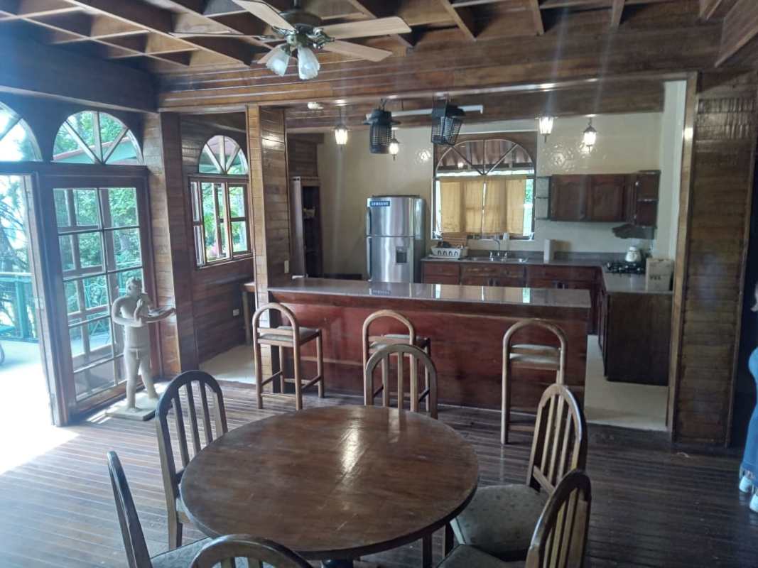 Rustic kitchen and dining area with wood cabinetry arched windows in mountain cabin Cerro Azul