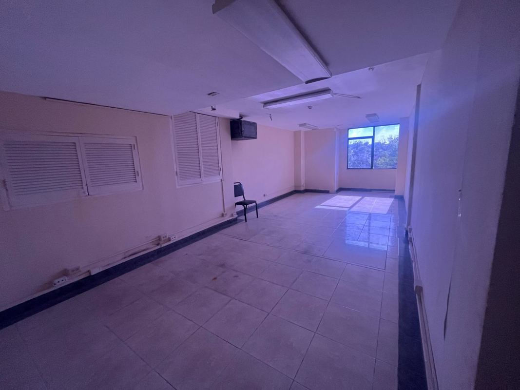 Interior hallway with elevators and emergency signage in multi-story commercial building
