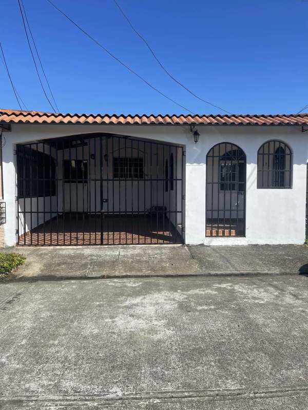 Mediterranean style exterior with clay tile roof, arched entry and covered driveway
