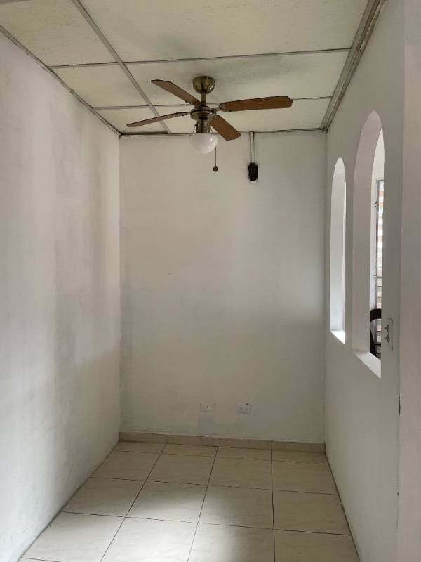Small room interior with tiled floor, white walls, ceiling fan and arched windows