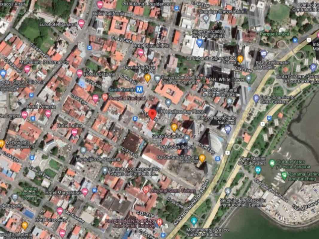 Reception area with office desks and a metal staircase leading to upper floor