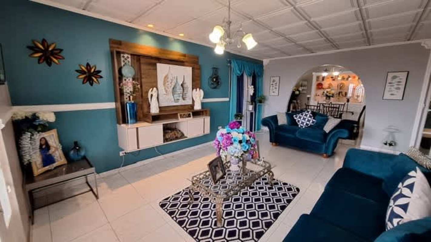 Large living room with teal accent wall, velvet sofas and archways San Antonio Panama