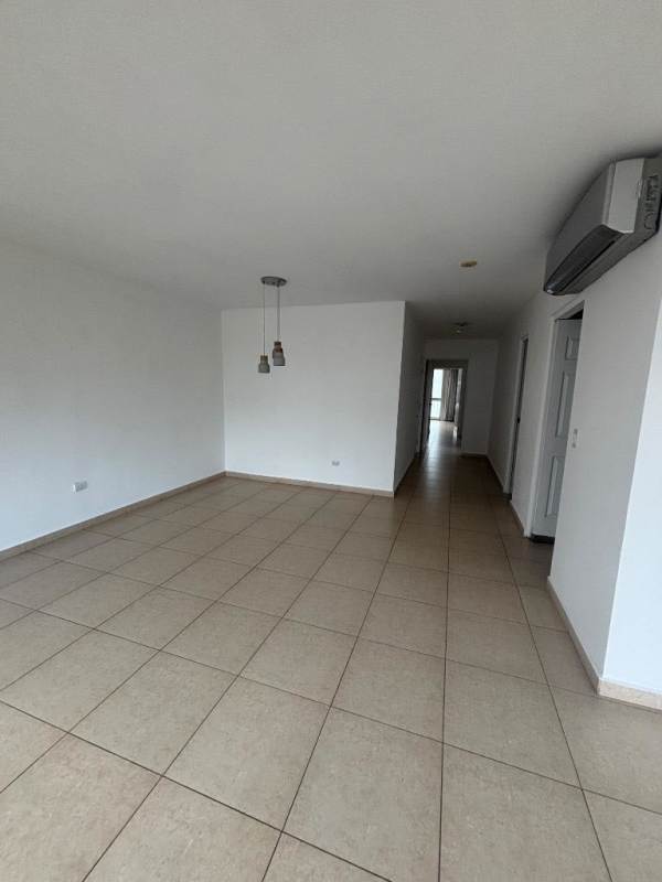 Spacious living room with tiled floor, floor-to-ceiling windows, balcony access in Costa del Este condo