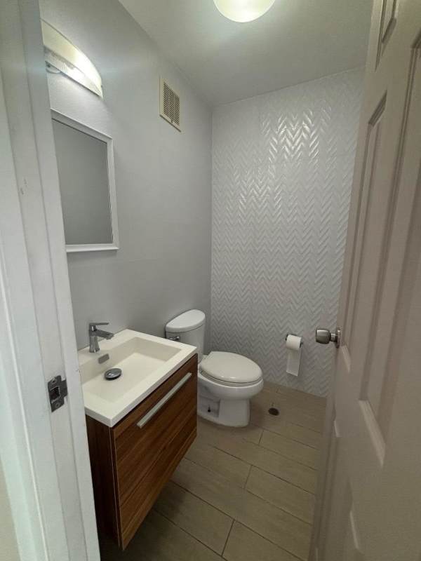 Stylish guest bathroom with elegant patterned wall and floating vanity at PH Costa View Costa del Este