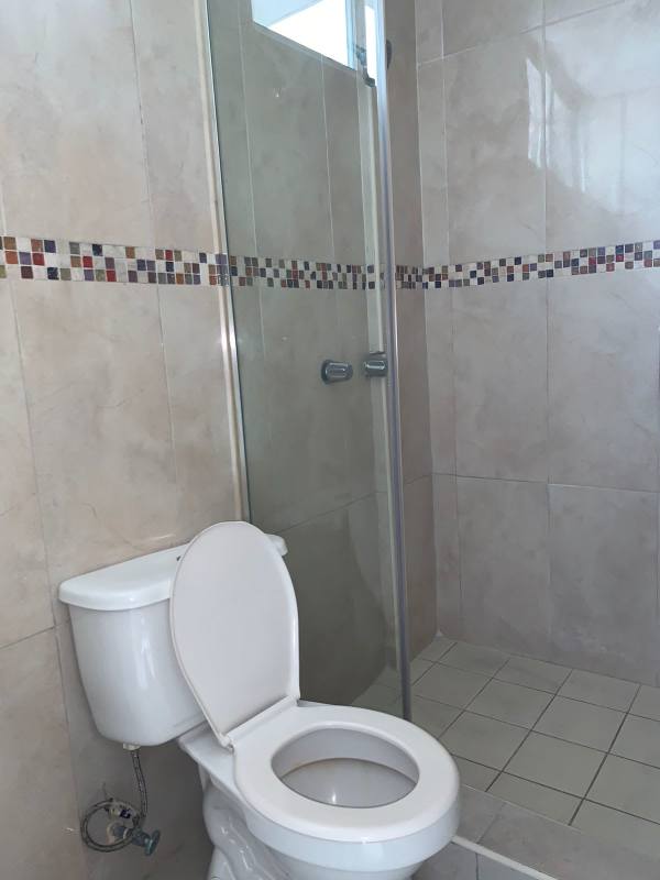 Bathroom with beige tiles, glass shower, single sink, El Cangrejo Panama apartment