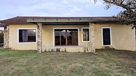 Bright open-plan living dining with sofas, glass table, large windows rental Los Molinos Boquete