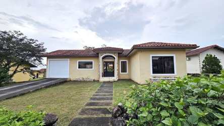 Single-story Mediterranean home exterior with tiled roof, garden and driveway in Los Molinos Boquete Panama