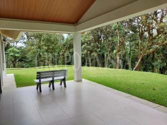 Outdoor covered terrace overlooking green garden in mountain house Altos del María Panama