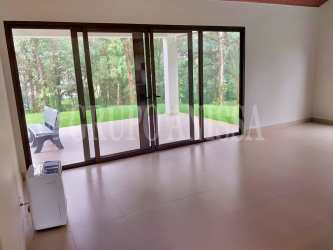 Exterior view of modern mountain house with large lawn surrounded by trees Altos del María Panama