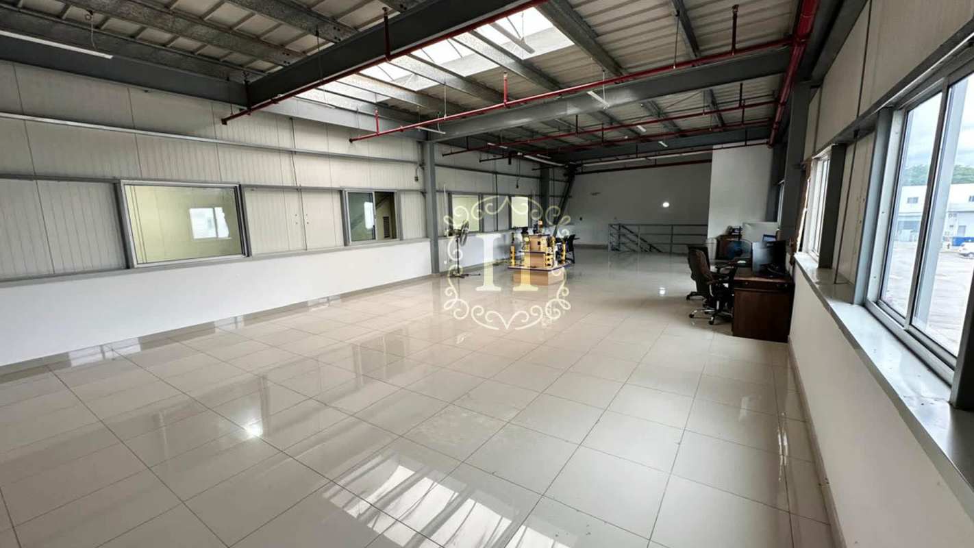 Industrial-style office mezzanine with windows and metal stairs inside warehouse Tocumen Panama