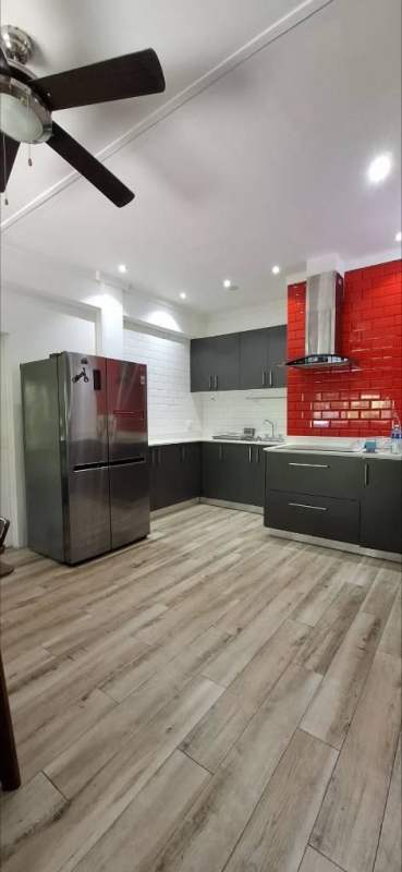 Modern kitchen with red subway tile backsplash dark cabinets stainless appliances Curundu Heights Panama