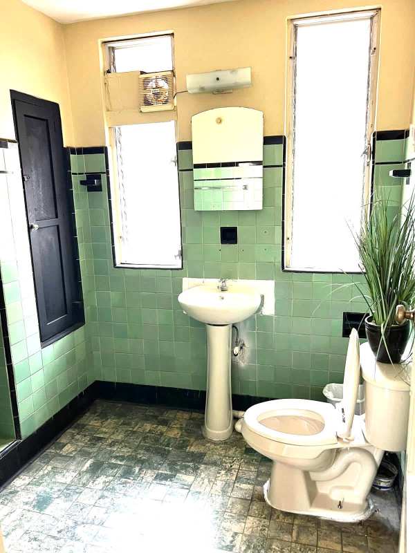 Mint green tiled bathroom with pedestal sink in Perejil Business Center Panama City