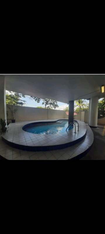 Covered outdoor swimming pool area with white columns at PH Miraflores Residences in Villa de las Fuentes Panama