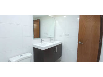 Modern bathroom with enclosed glass shower and vanity in Panama Pacifico apartment