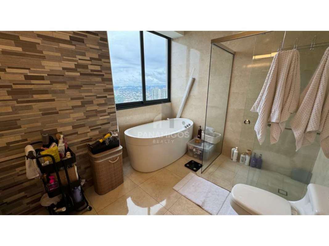 Modern bathroom with freestanding tub, large window and city views in PH Matisse Panama City