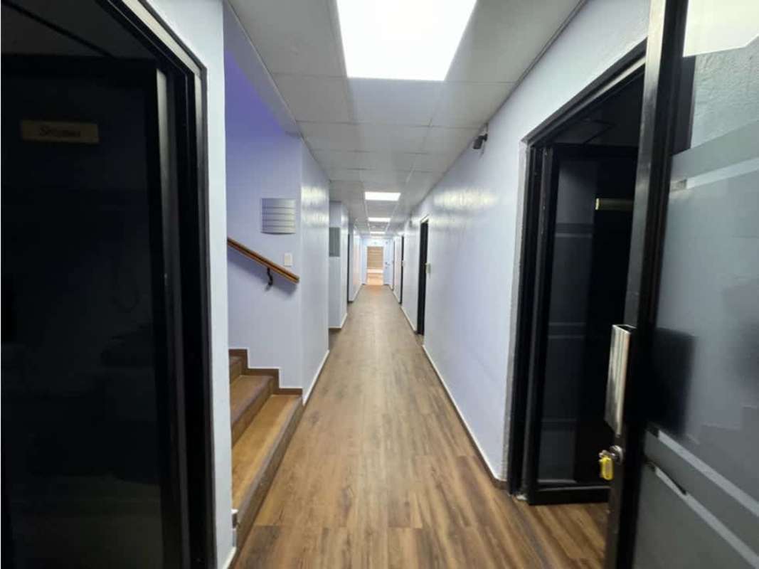 Long hallway with wood floors, light blue walls, fluorescent lighting in Corporate Building Costa del Este
