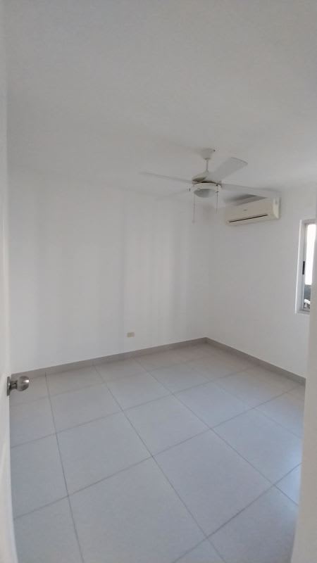 Minimalist bedroom with ceiling fan, large window, tile floor at PH Condado Country Club