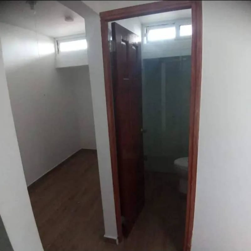 Small bathroom with glass shower connected to hallway wooden floor PH La Cresta Panama