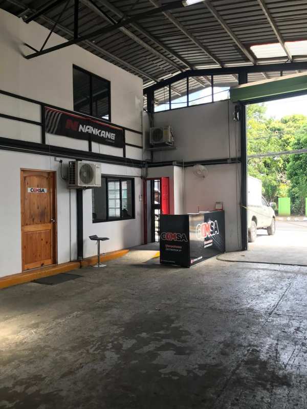 Reception area inside warehouse with open garage entrance, counter, air conditioning units, green view Santa Elena Panama