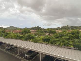 Bright open-plan living room with large windows and balcony access in Panama Pacifico apartment