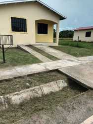 Side yard with lawn and fenced area outside affordable home in Rio Hato Panama