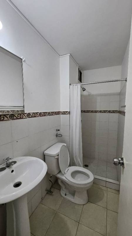 Basic bathroom with pedestal sink, shower, tile walls in Parques del Este Panama