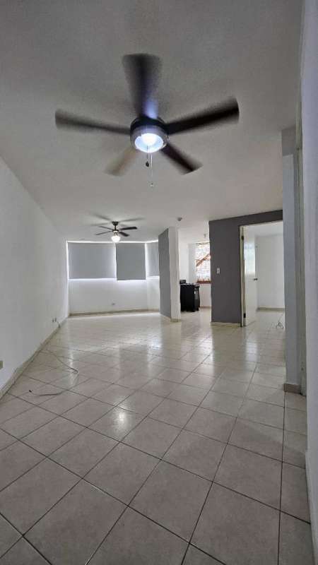 Open plan living and dining area with large tiled floors and ceiling fans in Don Bosco apartment