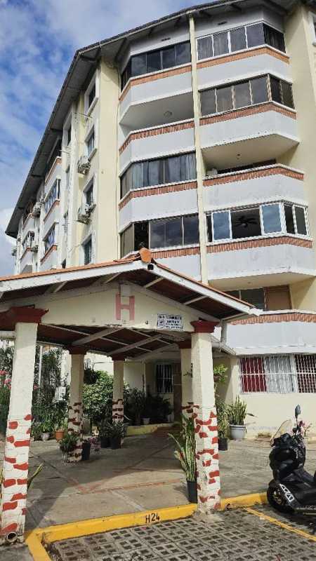 Exterior of mid-rise apartment building Parques del Este with covered entrance Panama City