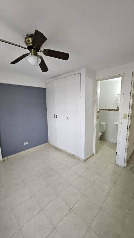 Bedroom with built-in wardrobe, ensuite bathroom, and ceiling fan Parques del Este Panama