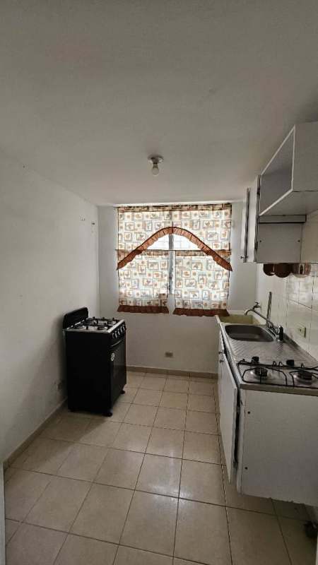 Compact apartment kitchen with cabinets, gas stove, window, tiled floor Parques del Este Panama