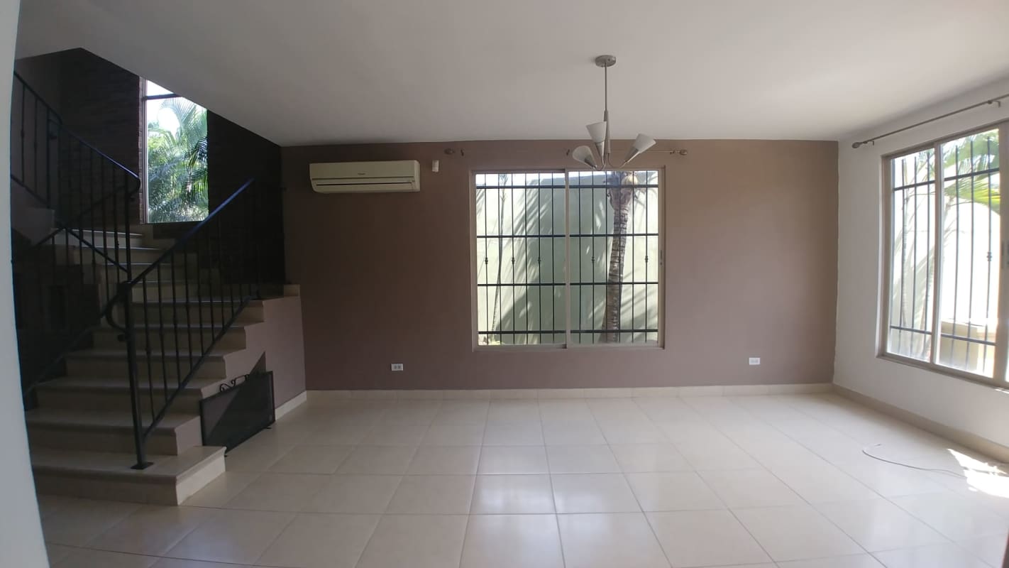 Living room with windows, AC, chandelier and stairs Condado del Rey house Panama