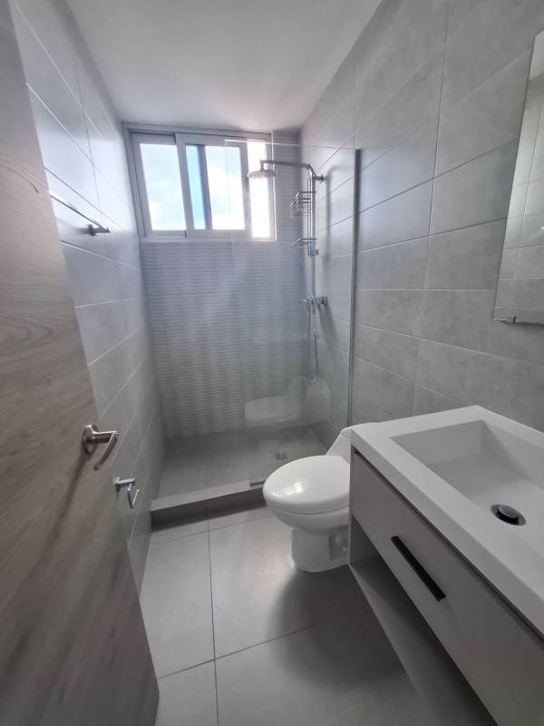 Minimalist bathroom with glass shower enclosure, wall-mounted vanity at PH Signature Point Panama City