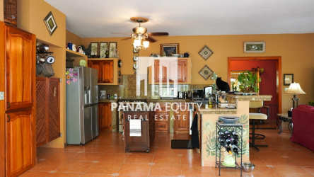 Traditional kitchen with granite countertops, island, wood cabinets in Altos del Maria Villa Valencia Panama