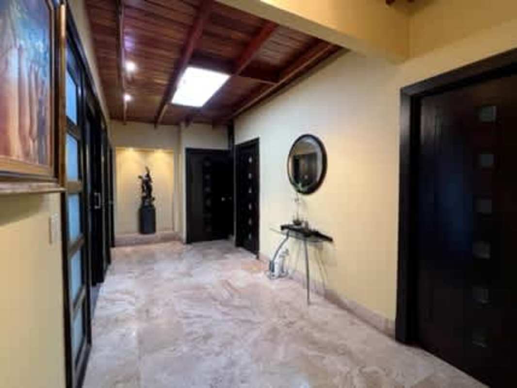 Bright hallway with marble floor, wooden ceiling, natural light, modern art in house San Francisco