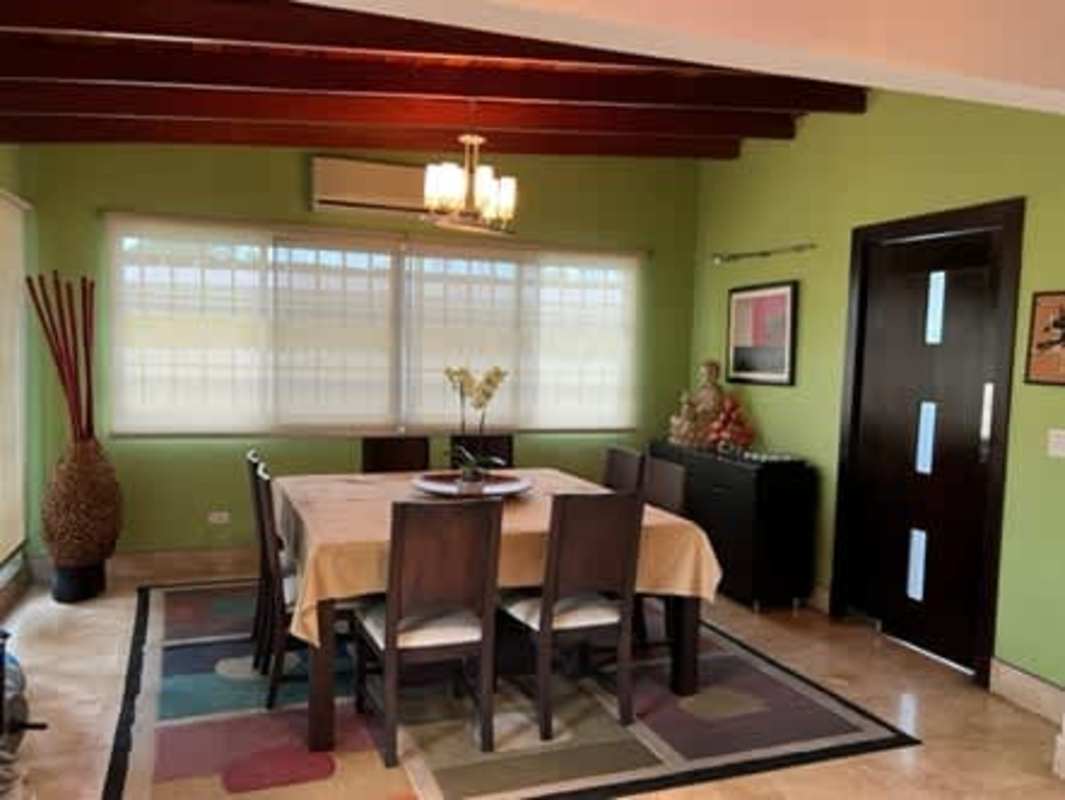Dining room with wooden ceiling beams, decor and large bright windows San Francisco Panama