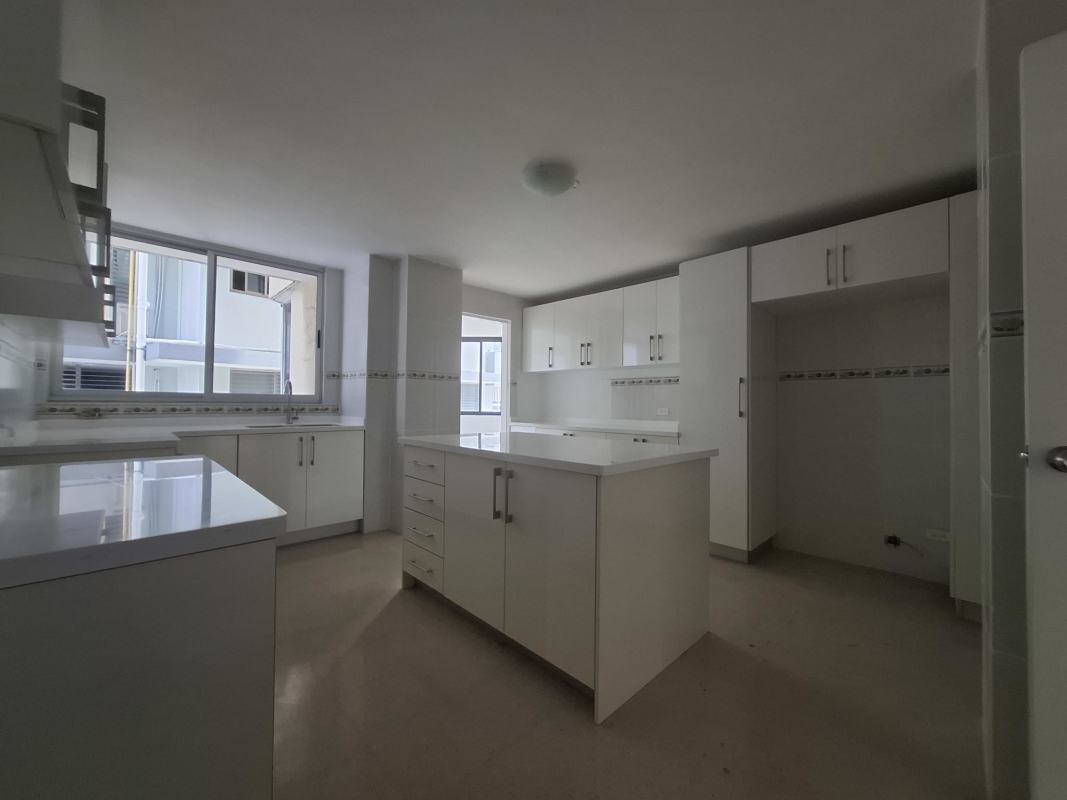 Wide white minimalist kitchen with granite floors and cabinetry at PH Savoy