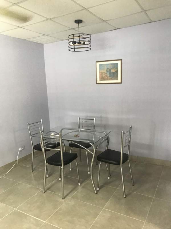 Family dining area with glass table and pendant light in Campo Lindbergh house Panama