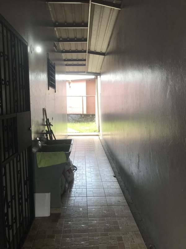 Covered laundry corridor with utility sink and metal gate Don Bosco Panama