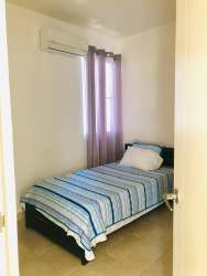 Bedroom with AC, tiled floors, large window, modern furniture in oceanfront condo Playa Dorada Panama